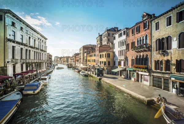 Ancient buildings and boats in the channel in Venice