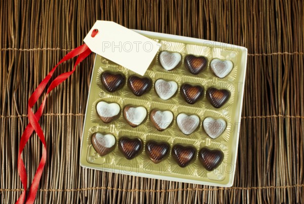 Chocolates in the shape of hearts. Chocolates in golden box and label