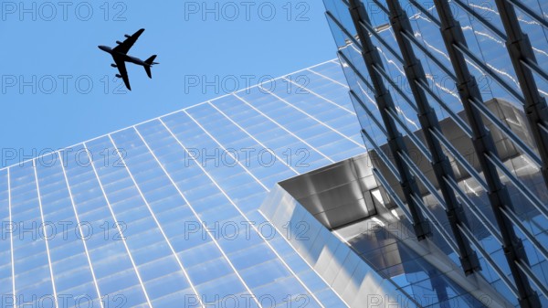 An image of a plane flying over modern buildings of New York City