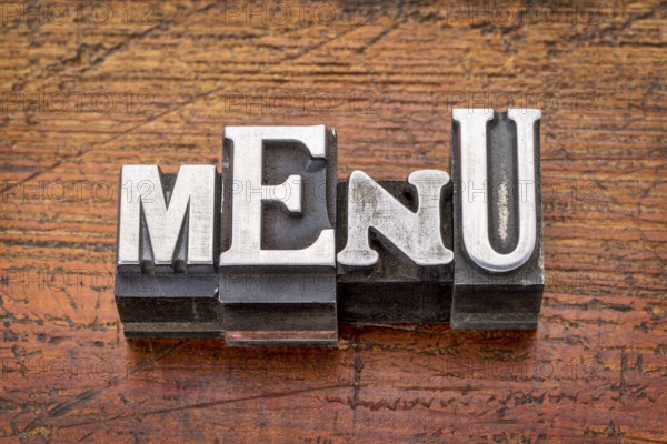 Menu word in vintage metal type printing blocks over grunge wood
