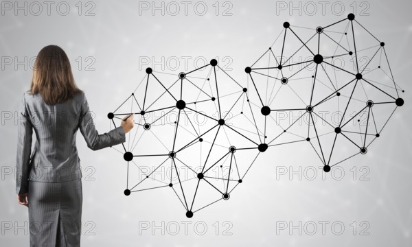 Businesswoman standing with back to camera and drawing with marker connection lines