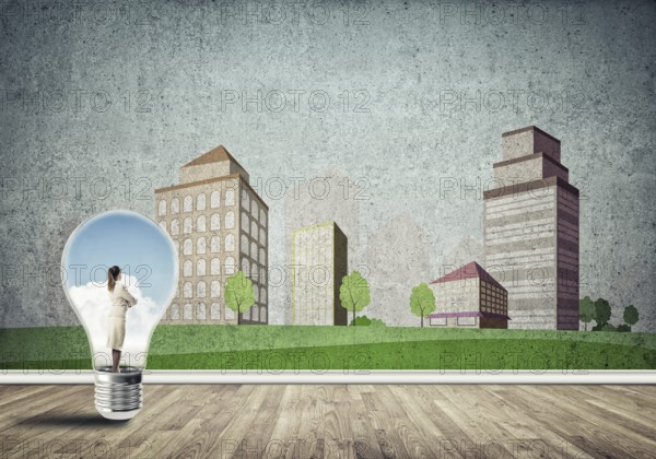 Businesswoman inside light bulb against city drawn concept