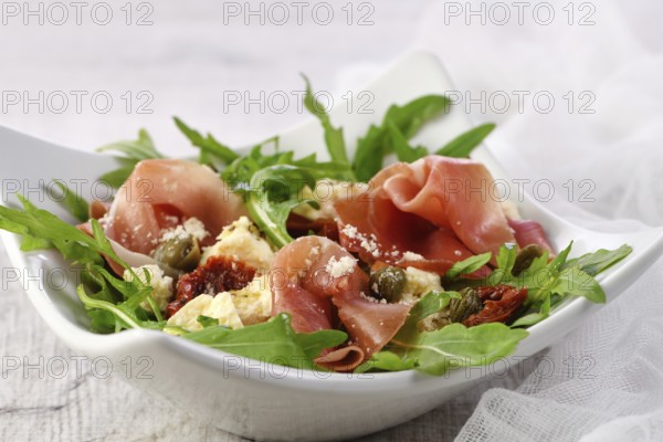 Arugula salad, prosciutto with sun-dried tomatoes, slices of mozzarella, capers, seasoned with olive butter and parmesan. A dish for those who monitor their health