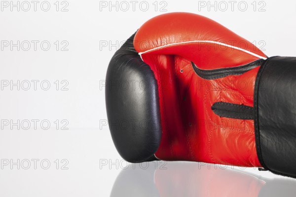 Red and black boxing gloves on a glass table isolated on white background
