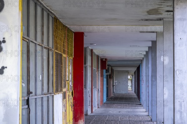 Abandoned row of shops with colourful doors and graffiti