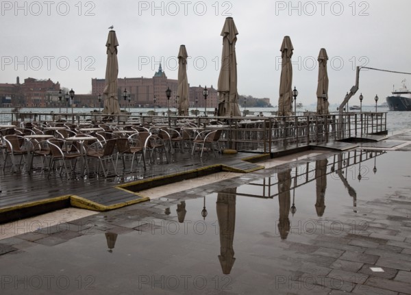 Italy Venice Zattere quay -145 Restaurant terrace on a pontoon on the Canale della Guidecca in November in the background the Stucky mill today hotel