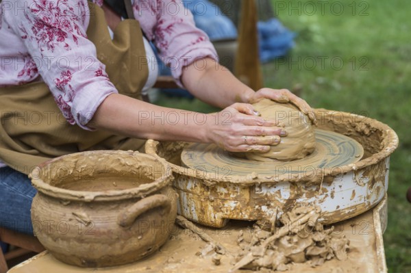 Hands of a woman making a clay pot on a potter's wheel in Boleslawiec, Poland, Europe