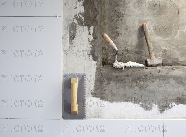 Construction tools notched trowel on tiles mortar wall