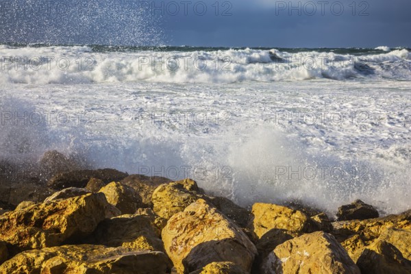 New Quay in the Old Jaffa in a winter storm. Huge foaming waves of the Mediterranean beat against the shore rocks. Tel Aviv in January