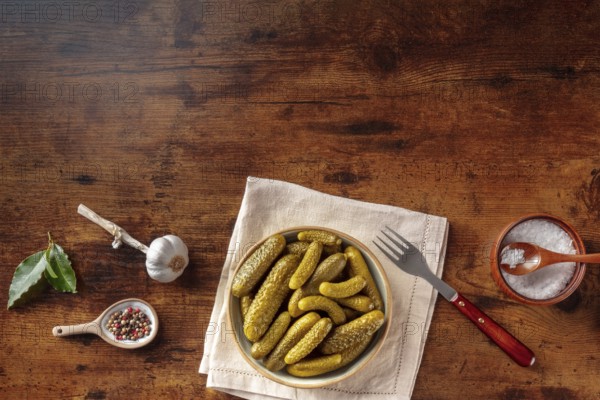 Pickled cucumbers with salt, pepper, garlic, and bay leaf. Fermented food. Homemade canned gherkins. Overhead flat lay shot with copy space, Food photography