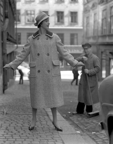 Fashionable in the 1950s. A young woman wears a typical 1950s coat. She poses in the outfit in a street. Sweden 1950s. Photo Kristoffersson Ref 314A-1