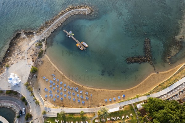 Drone aerial of tropical sandy beach. Beach umbrellas people swimming and relaxing. Summer vacations. Ayia triada, Protaras Cyprus