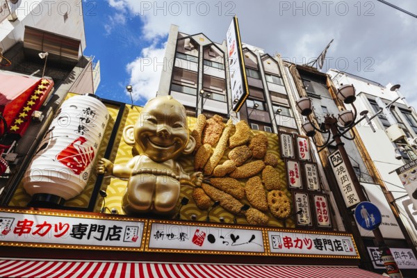 OSAKA, JAPAN - SEPTEMBER 24 2024: Osaka's famous Dotonbori area with many restaurants and iconic food signage, including this golden baby in Osaka, Japan, Asia