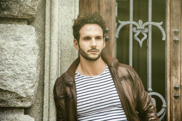 Attractive young man outdoor wearing leather jacket, in European city, Turin in Italy