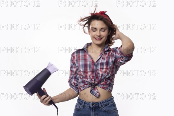 A trendy and fashionable young woman holding a hair dryer, fully embracing both style and beauty in her life