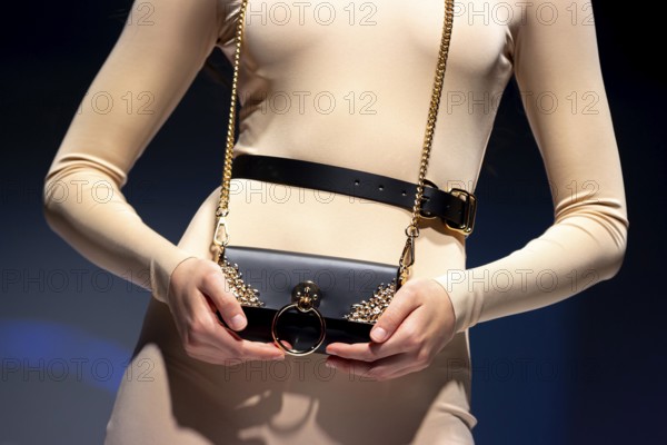 A female model presents a creation during a Fashion week. Presenting a corset and a small black purse