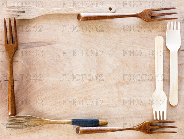 Wooden kitchenware frame on a wooden background from above. Studio shot. Kitchen utensil