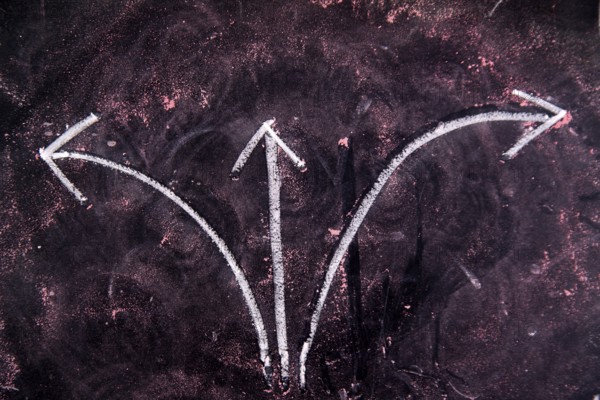 Graphical representation with chalk on blackboard three arrows showing different directions