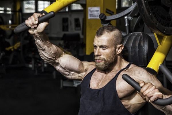An image of a handsome bearded bodybuilding man doing chest workout
