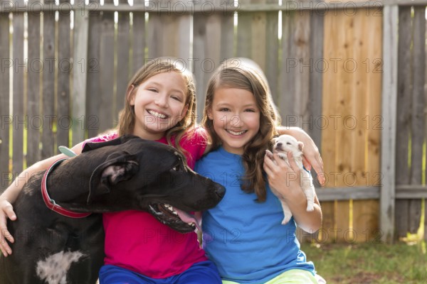 Twin sisters puppy pet dog and great dane playing together