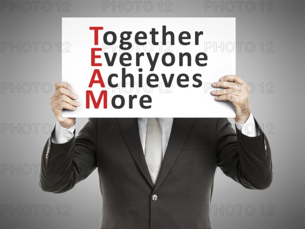 A business man holding a paper in front of his face with the text Together Everyone Achieves More