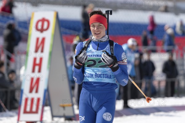 Portrait of sportsman biathlete Sporshev Nikita at finish line after skiing and rifle shooting. Junior biathlon competitions East of Cup. Petropavlovsk, Kamchatka Peninsula, Russia, April 14, 2019, Europe