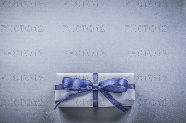 Wrapped gift box on blue background holidays concept