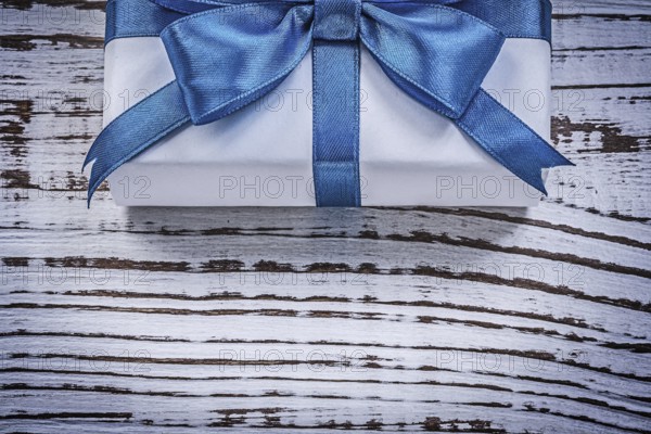 Wrapped gift box on vintage wooden board holidays concept