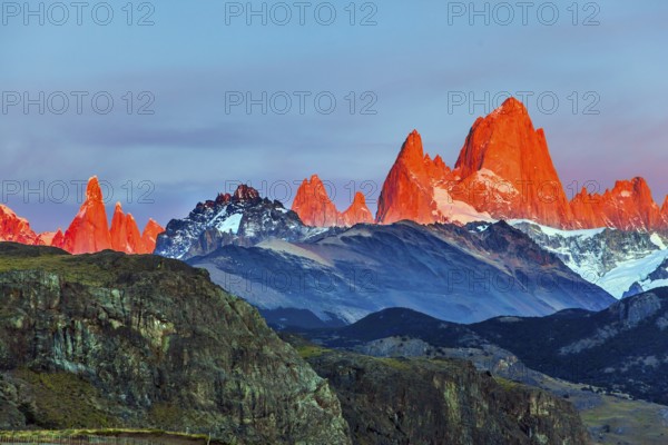 The grand crimson dawn over the mountain range Fitzroy. Mountain peak in Patagonia. Magnificent mountain range, illuminated by the sunrise sun. The concept of extreme, active and photo tourism