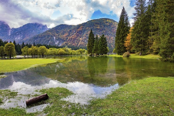 Midday in a mountain valley. Picturesque shallow lake Fuzine of glacial origin. The lake shores are flooded. Wonderful warm autumn day