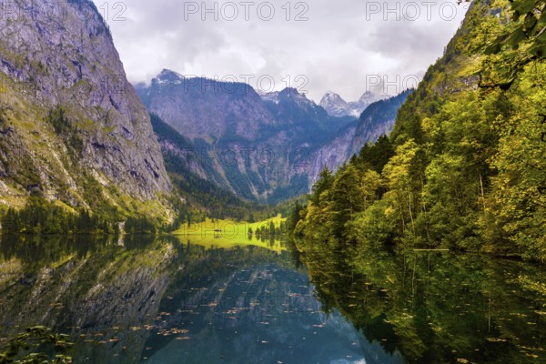 Koenigssee - the cleanest lake in Germany is surrounded by high mountains. The fabulous beauty in Bavaria. The slopes of the mountains are reflected in the cold water. The concept of active, ecological and phototourism
