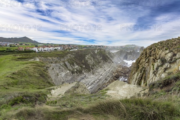 Cantabria Beaches, Portio Beach. Windy stormy day on the Atlantic coast. Giant rough gray rocks and smooth sandy beach. Noon on the beach of Playa di Arnia, Spain, Europe
