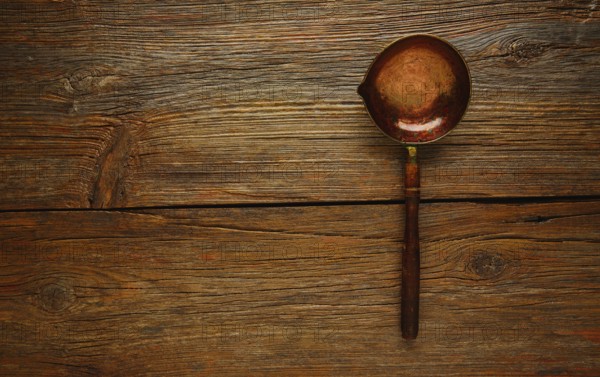 Aged cooper ladle vintage on wooden table retro