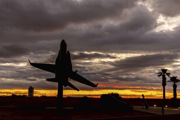 Dawn at Naval Air Field El Centro, CA: Sunlight paints vibrant hues across the sky, casting a mesmerizing rainbow over parked aircraft, creating a breathtaking spectacle