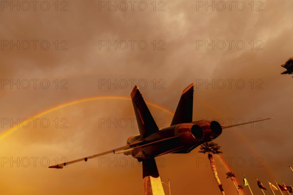 Dawn at Naval Air Field El Centro, CA: Sunlight paints vibrant hues across the sky, casting a mesmerizing rainbow over parked aircraft, creating a breathtaking spectacle