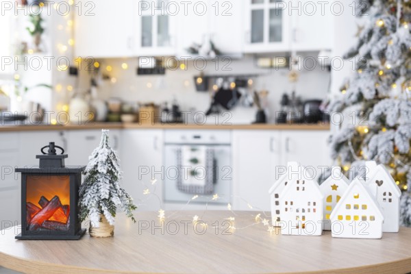Cozy Christmas decor tiny house of small size on table of festive white modern kitchen. Gift for New Year. Insurance, moving to new house, mortgage, rent and purchase real estate