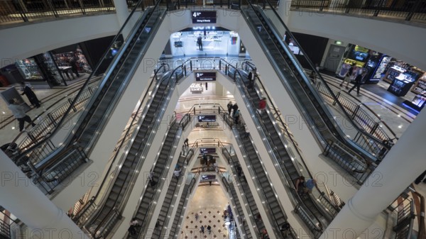 High angle shot of modern multistorey shopping mall. People traffic on the escalators of each floor. Trade centre in Petronas Twin Towers in Kuala Lumpur, Malaysia, Asia