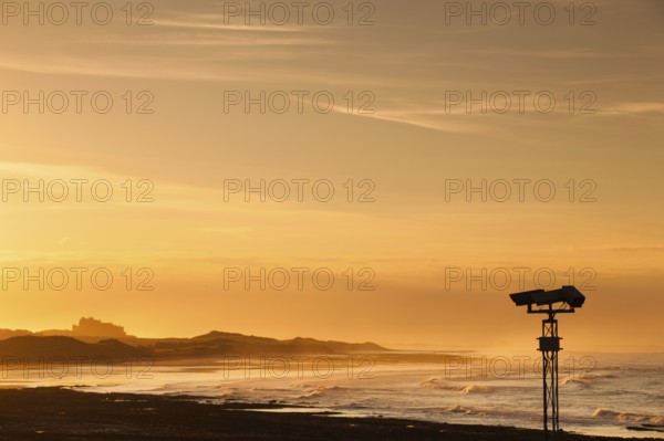 View of the Bamburgh castle in a spectacular sunset from the Seahouses, Great Britain