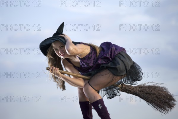Pretty witch with hat and broom, outdoors