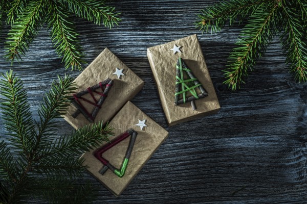 Handmade present boxes fir tree branch on wooden board