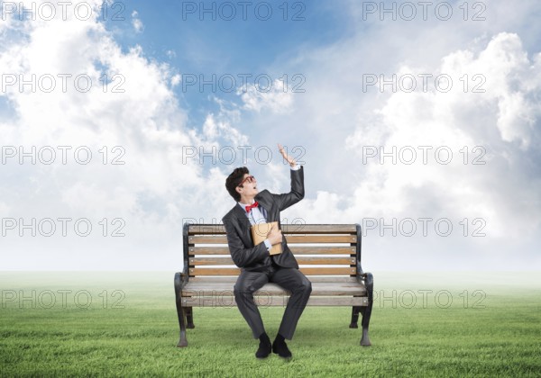 Young student with a book. sits on a wooden bench