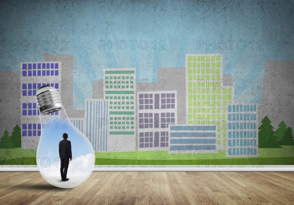 Businessman inside light bulb against city drawn concept