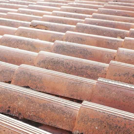Old tiled roof. Close up of the red clay roof tiles. Background of old roof