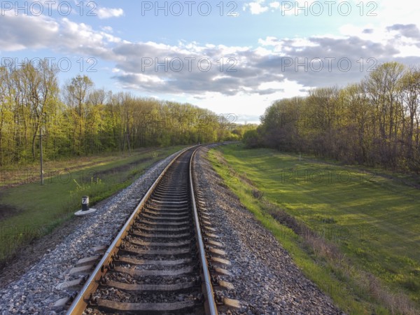 Railway, tracks through tree planting, green grass and beautiful nature, travel through Ukrainian steppes and forests