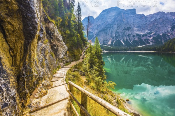 The concept of environmental and hiking. Walking trail around the lake is fenced with wooden railings. Magnificent Alpine lake Lago di Braies