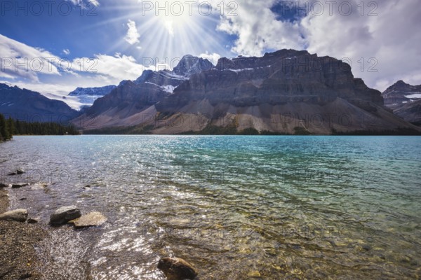 The cold waters of the lake surrounded by scenic Canadian Rocky Mountains. Azure Bow Lake in Banff National Park