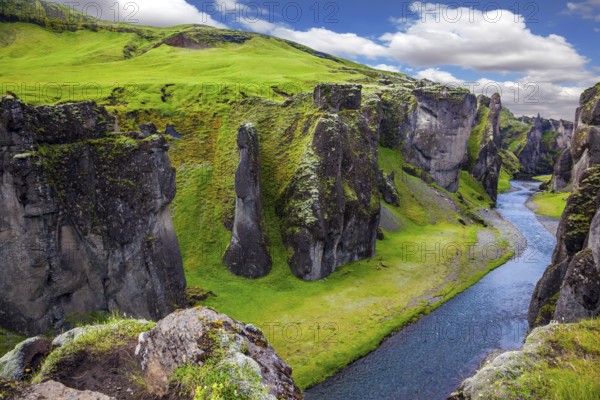 Magic beauty canyon in Iceland - Fyadrarglyufur. Steep cliffs, overgrown with green moss, surrounded by fast river with cold water