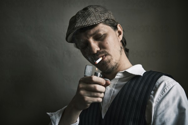 Young guy lights a cigarette, blows smoke, dressed in a retro style, in a beret, cinematic shot, big closeup