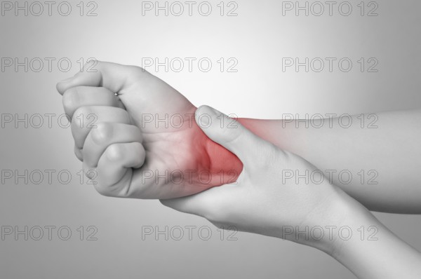 A young woman holding her painful wrist