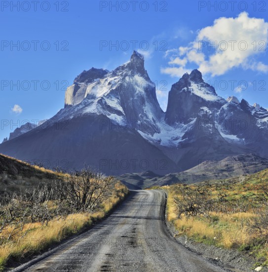 Dreamland Patagonia. Snow-covered cliffs of Los Cuernos, to them is a road of black gravel
